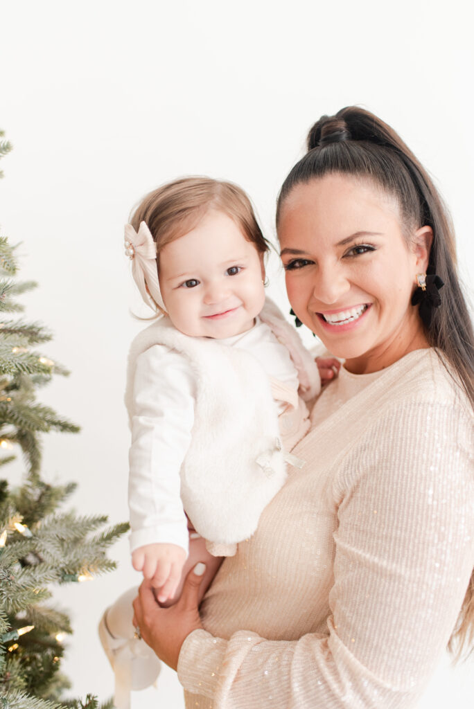 mom and 1 year old baby in front of a Christmas tree Miami Christmas Mini Session