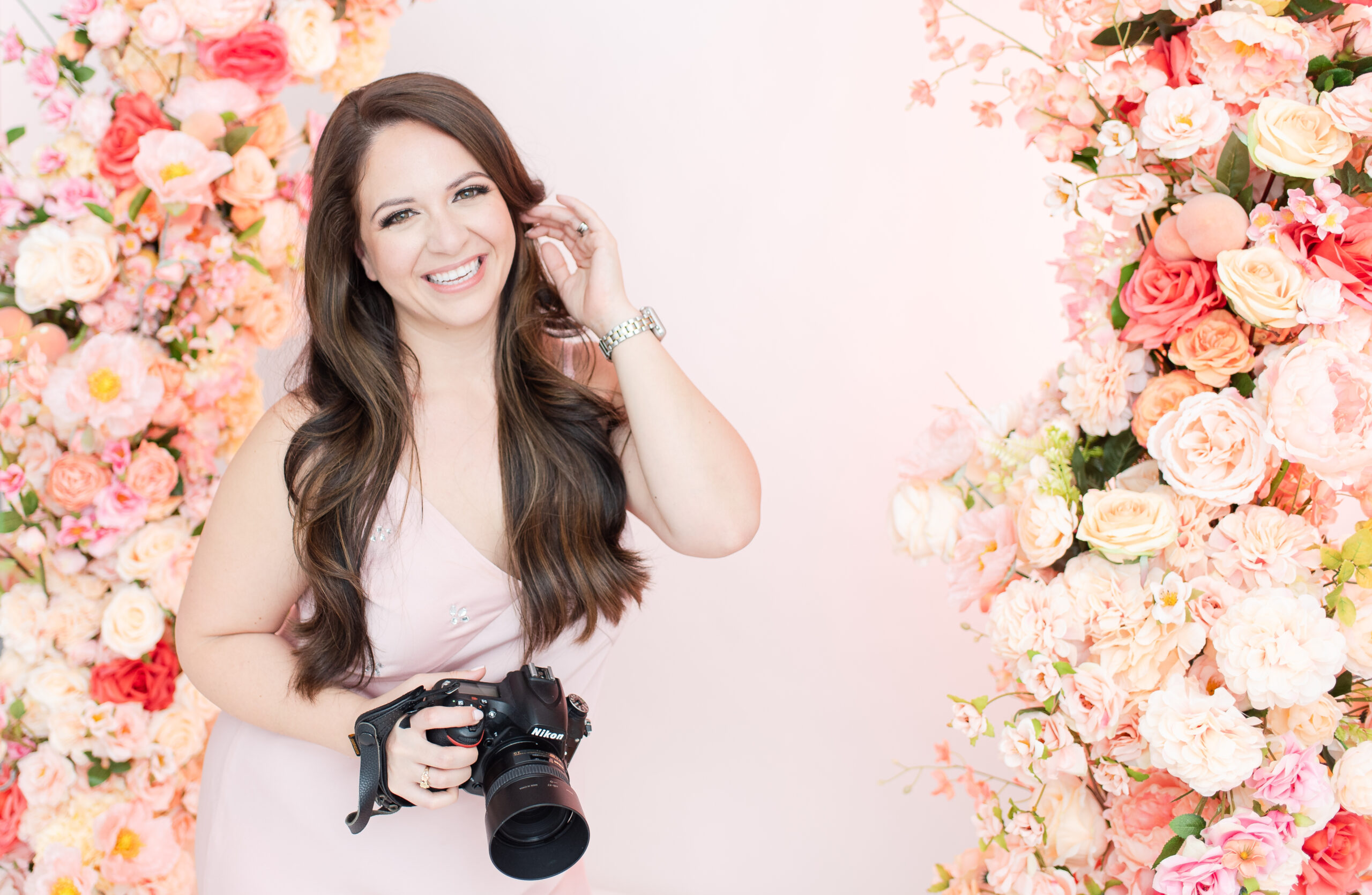 miami family photographer headshot in front of florals for a mother's day mini session