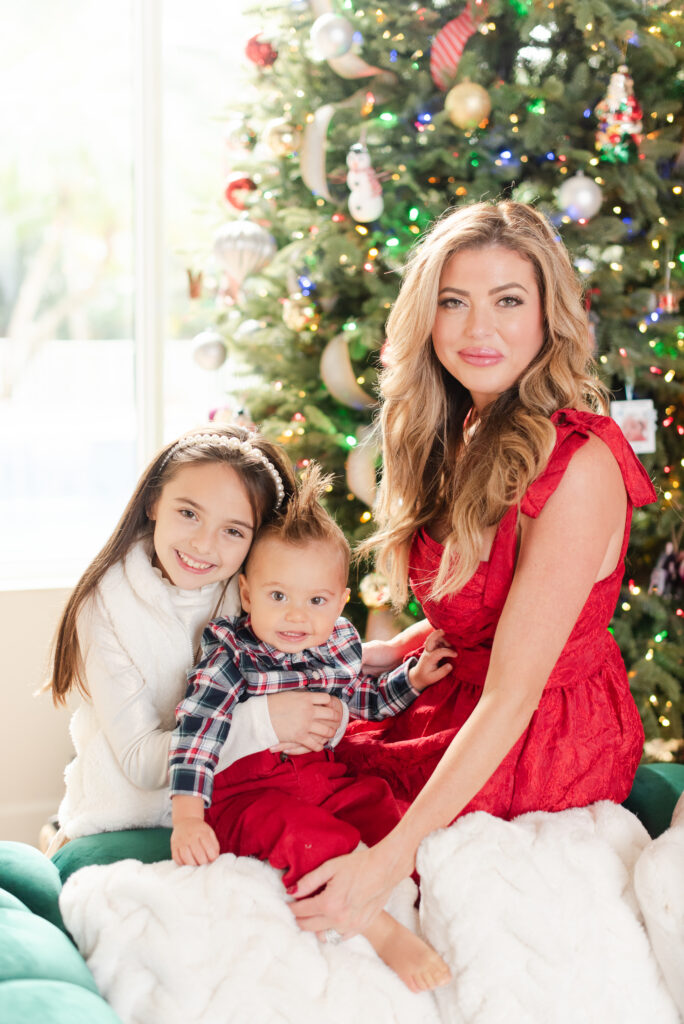 Mom and two kids in front of a Christmas tree wearing traditional Christmas outfits at in home Christmas Family Photoshoot