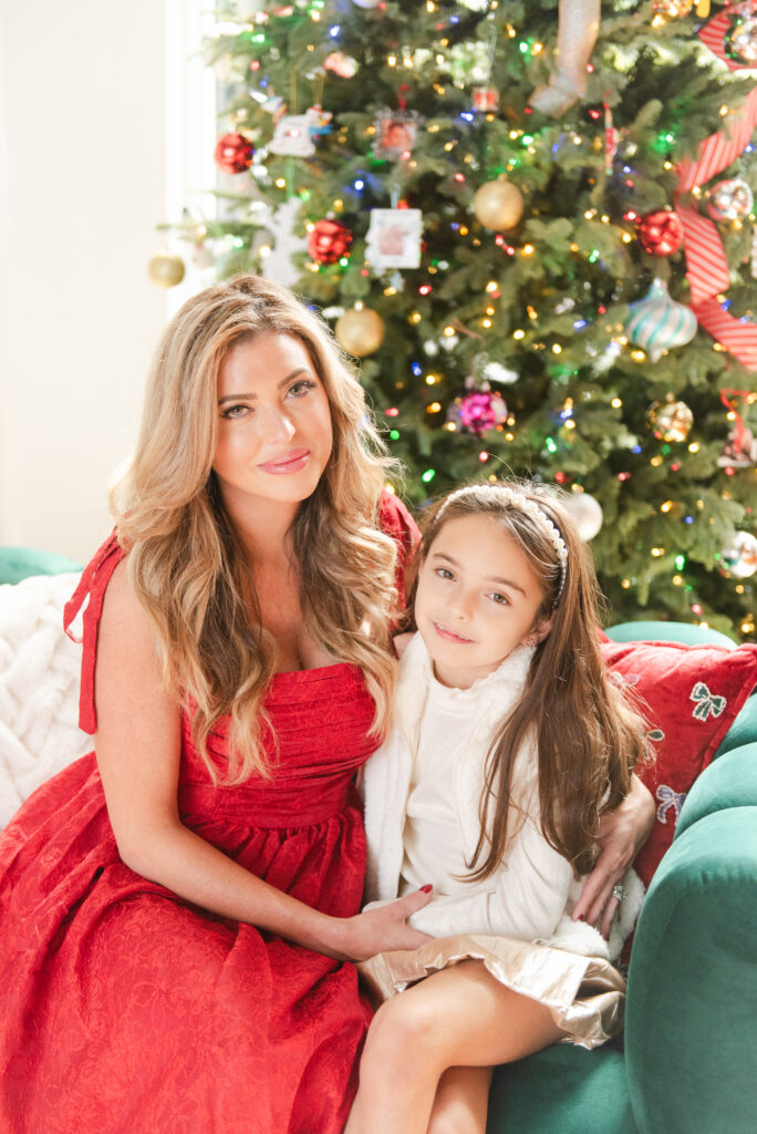 Mother and daughter wearing traditional Christmas dresses at in home family session during the holidays