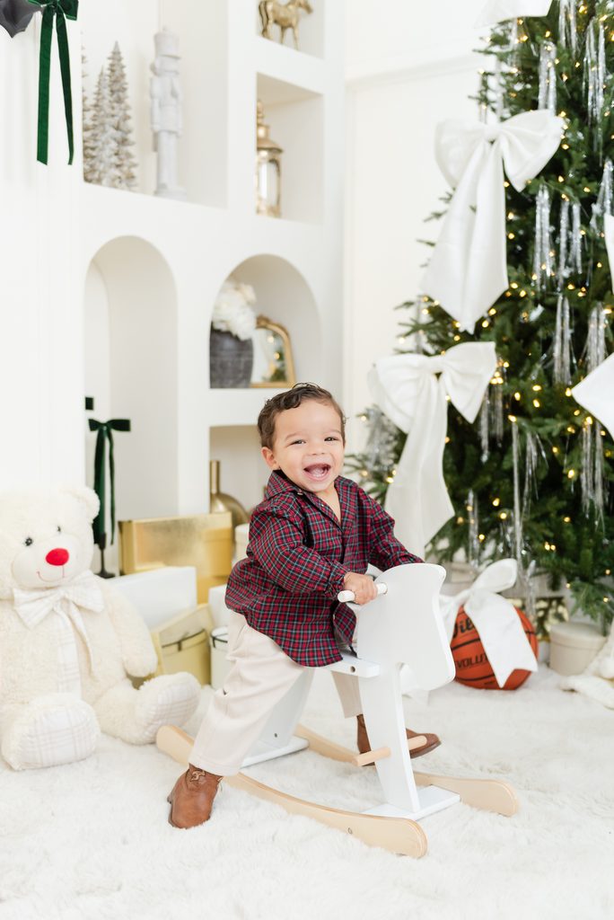 Toddler on rocking horse in Christmas Photoshoot in Miami, playful natural poses by MSP Lifestyle Miami Family Photographers