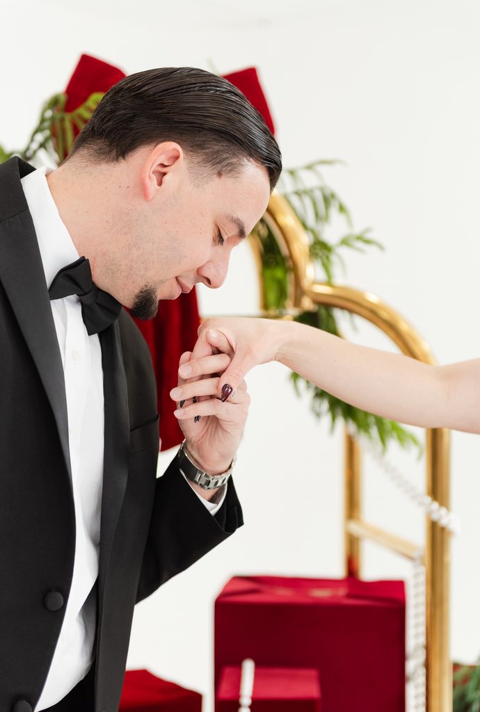 Husband kissing hand of wife at a Christmas Photoshoot in Miami, editorial bellman photos in Miami playful poses by MSP Lifestyle Miami Family Photographers